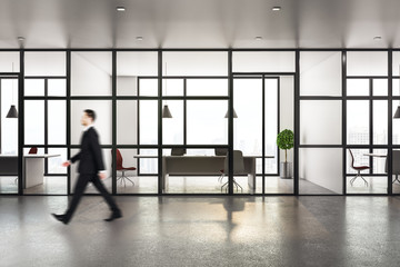 Businessman walking in modern workplace corridor