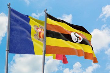 Uganda and Andorra flags waving in the wind against white cloudy blue sky together. Diplomacy concept, international relations.