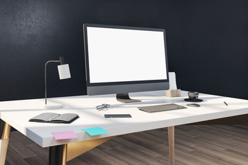 Designer desktop with blank computer screen