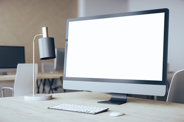 Designer desktop with empty computer screen.