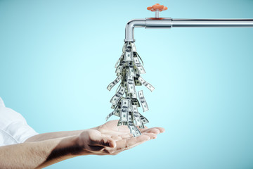 Fototapeta na wymiar Businessman puts hands to water tap dripping dollar bills
