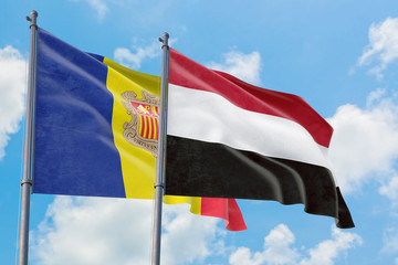 Yemen and Andorra flags waving in the wind against white cloudy blue sky together. Diplomacy concept, international relations.