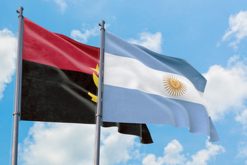 Argentina and Angola flags waving in the wind against white cloudy blue sky together. Diplomacy concept, international relations.