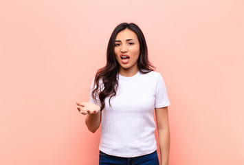young latin pretty woman looking angry, annoyed and frustrated screaming wtf or what‚Äôs wrong...
