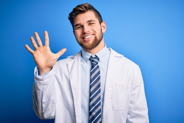 Young blond therapist man with beard and blue eyes wearing coat and tie over background showing and pointing up with fingers number five while smiling confident and happy.