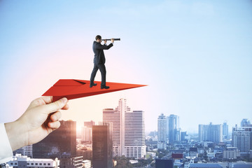 Businessman with telescope looking into distance while