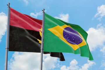 Brazil and Angola flags waving in the wind against white cloudy blue sky together. Diplomacy...