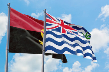 British Indian Ocean Territory and Angola flags waving in the wind against white cloudy blue sky together. Diplomacy concept, international relations.