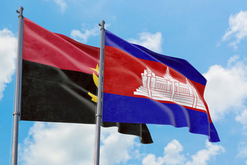 Cambodia and Angola flags waving in the wind against white cloudy blue sky together. Diplomacy...