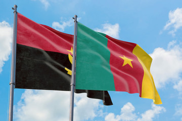 Cameroon and Angola flags waving in the wind against white cloudy blue sky together. Diplomacy concept, international relations.