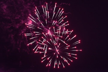 Beautiful inexpensive red fireworks against the dark sky. With smoke.