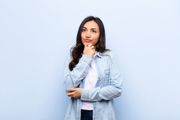 young latin pretty woman thinking, feeling doubtful and confused, with different options, wondering...