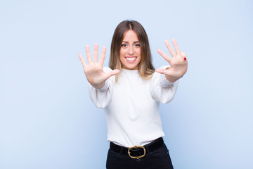 young pretty hispanic woman smiling and looking friendly, showing number nine or ninth with hand...