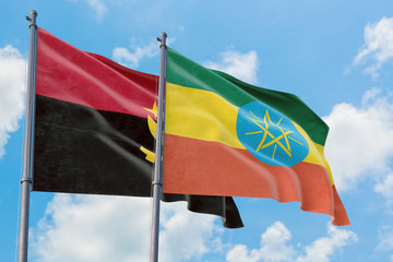 Ethiopia and Angola flags waving in the wind against white cloudy blue sky together. Diplomacy concept, international relations.