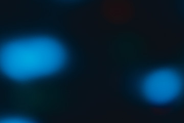 Blue bokeh on black background close up.