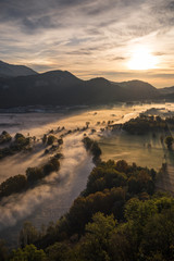 Abstract with Airuno on Adda river in Italy at sunrise with myst fog trees foliage in autumn fall...