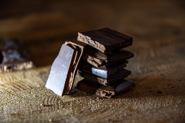 Dark chocolate with filling on a wooden table.