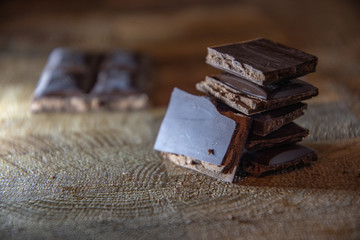 Dark chocolate with filling on a wooden table.