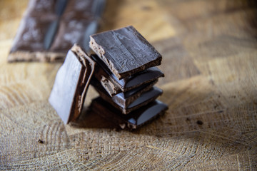 Chocolate pyramid from the pieces of chocolate with filling on a wooden table.