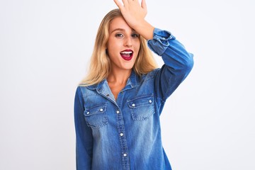 Young beautiful woman wearing casual denim shirt standing over isolated white background surprised...