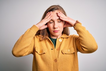 Young beautiful blonde woman wearing casual sweater over isolated white background suffering from headache desperate and stressed because pain and migraine. Hands on head.