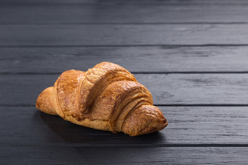 Croissants on a black wooden table. Croissant breakfast. Croissants on a wooden board and a black wooden table. Fresh French Baked Croissants. Warm Fresh Buttery Rolls. Free space for text.