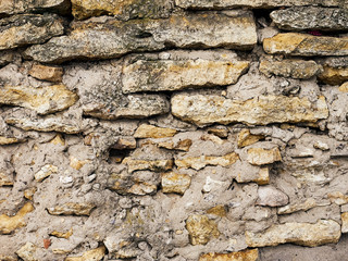Old stone wall of colored stones close-up background texture
