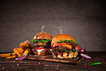 Close-up of home made tasty burgers on wooden table.