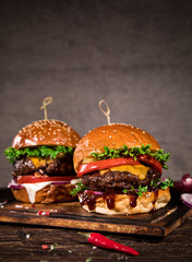 Close-up of home made tasty burgers on wooden table.