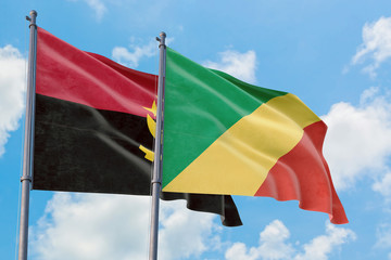 Republic Of The Congo and Angola flags waving in the wind against white cloudy blue sky together. Diplomacy concept, international relations.