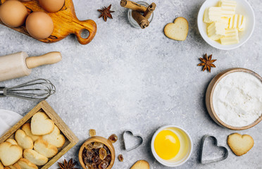 Valentine's Day baking culinary background. Ingredients for cooking on wooden kitchen table, baking recipe for pastry. Heart shape cookies.