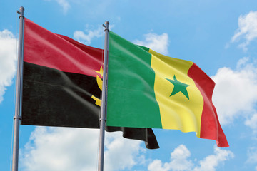 Senegal and Angola flags waving in the wind against white cloudy blue sky together. Diplomacy concept, international relations.