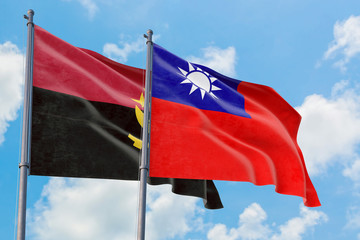 Taiwan and Angola flags waving in the wind against white cloudy blue sky together. Diplomacy concept, international relations.