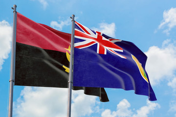 Turks And Caicos Islands and Angola flags waving in the wind against white cloudy blue sky together. Diplomacy concept, international relations.