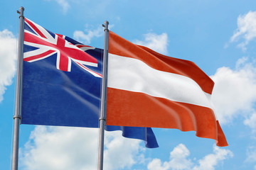 Austria and Anguilla flags waving in the wind against white cloudy blue sky together. Diplomacy concept, international relations.