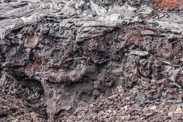 Leilani Estate, Hawaii, USA. - January 14, 2020: 2018 Kilauea volcano eruption hardened black lava field. Closeup of composition of layer with browns and reds.