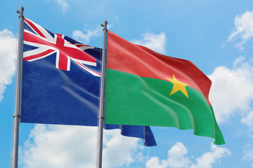 Burkina Faso and Anguilla flags waving in the wind against white cloudy blue sky together. Diplomacy concept, international relations.