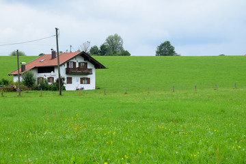 Fototapeta na wymiar Baviera / Germany - July 28, 2019: Farmhouse in a green field