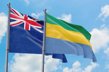 Gabon and Anguilla flags waving in the wind against white cloudy blue sky together. Diplomacy concept, international relations.