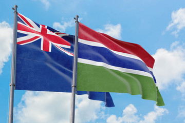 Gambia and Anguilla flags waving in the wind against white cloudy blue sky together. Diplomacy concept, international relations.