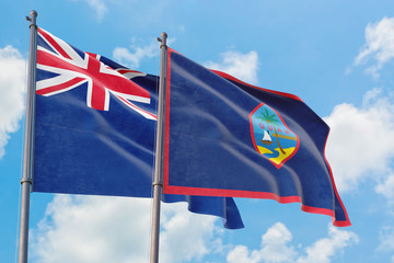 Guam and Anguilla flags waving in the wind against white cloudy blue sky together. Diplomacy concept, international relations.