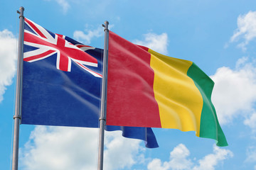 Guinea and Anguilla flags waving in the wind against white cloudy blue sky together. Diplomacy concept, international relations.