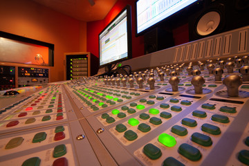 Close-up of multi colored buttons on sound mixer by computers at recording studio