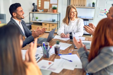 Group of business workers smiling happy and confident. Working together with smile on face applauding one of them at the office