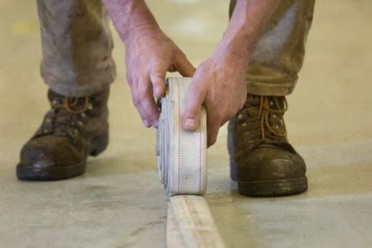 Closeup of hands rolling up firehose