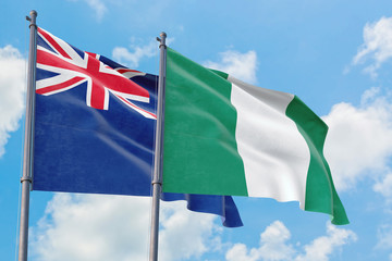 Nigeria and Anguilla flags waving in the wind against white cloudy blue sky together. Diplomacy concept, international relations.