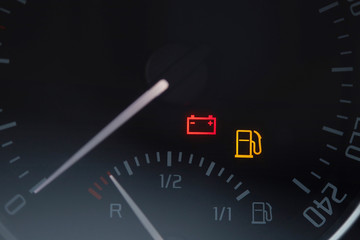 Close up shot of a car dashboard with the battery icon lit. Empty fuel gauge warning light in car...