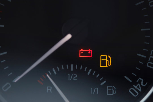 Close up shot of a car dashboard with the battery icon lit. Empty fuel gauge warning light in car dashboard