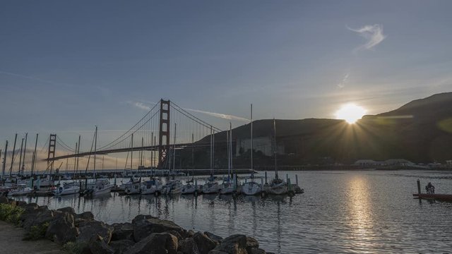 Time-Lapse at Fort Baker in Sausalito, Ca of a sunset with fog and ships rolling under and over the Golden Gate Bridge at the marina 