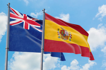 Spain and Anguilla flags waving in the wind against white cloudy blue sky together. Diplomacy concept, international relations.